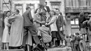 Juchés sur une Jeep, des Bruxellois entourent un militaire britannique, rue Royale, à hauteur de la Colonne du Congrès. Le lundi 4 septembre 1944, les habitants de la capitale font la fête à leurs héros.