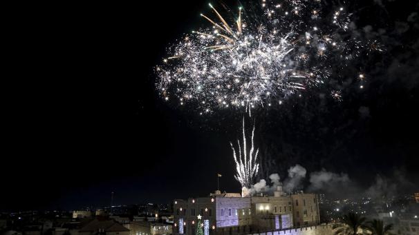 Des feux d'artifice illuminent la vieille ville de Jérusalem, lors d'une cérémonie marquant l'illumination de l'arbre de Noël, le dimanche 11 décembre 2022.
