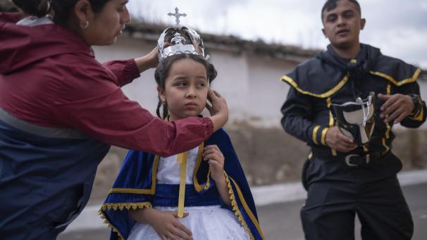 Une femme place une couronne sur la tête de sa fille âgée de 7 ans et habillée en Vierge de l'Immaculée Conception, lors de la «La quema del diablo» au Guatemala.