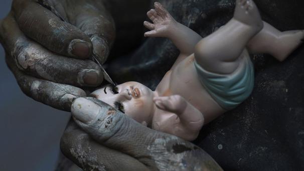Un homme répare une figurine de l'Enfant Jésus à Mexico City, ce mercredi 25 janvier 2023.