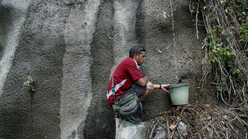 Le désespoir continue au Venezuela. Un homme ramasse ce qu’il peut d’eau dans un parc national. La denrée n’est plus disponible dans les habitations de Caracas.