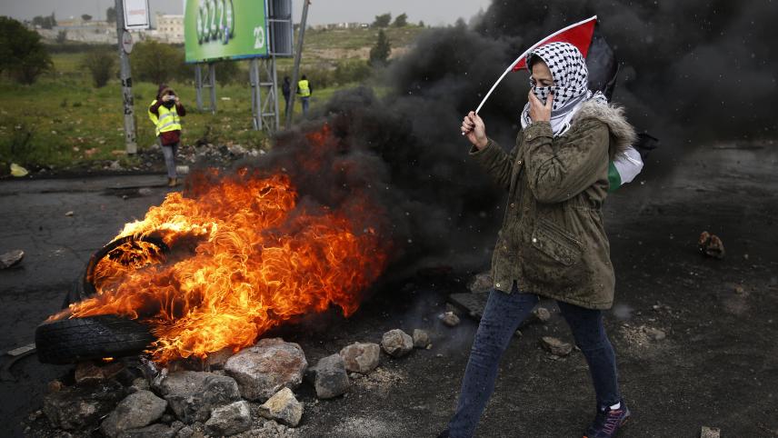 Une Palestinienne porte le drapeau national lors d’affrontements avec les forces israéliennes, à la suite d’une manifestation pour marquer la Journée de la Terre.
