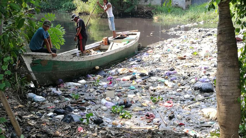 La rivière Loji Pekalongan, en Indonésie, voit ses rives jonchées de déchets. Des hommes tentent de nettoyer la catastrophe.