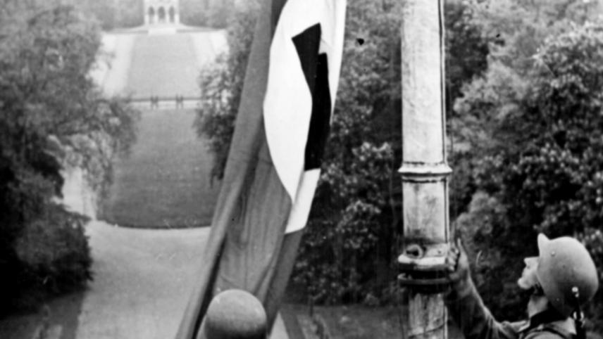 Les soldats de la Wehrmacht hissent le drapeau nazi sur le toit du château royal de Laeken.