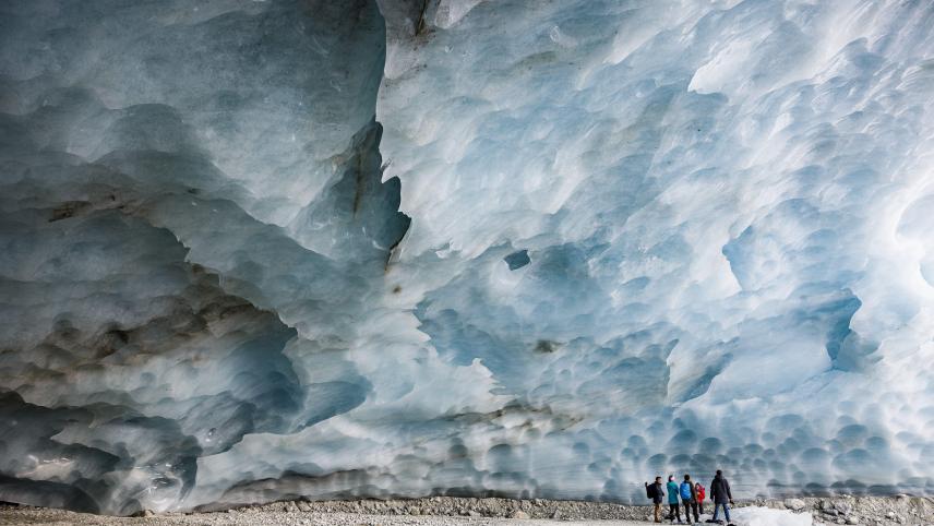 Des randonneurs visitent une grotte formée dans le glacier de Zinal en Suisse.