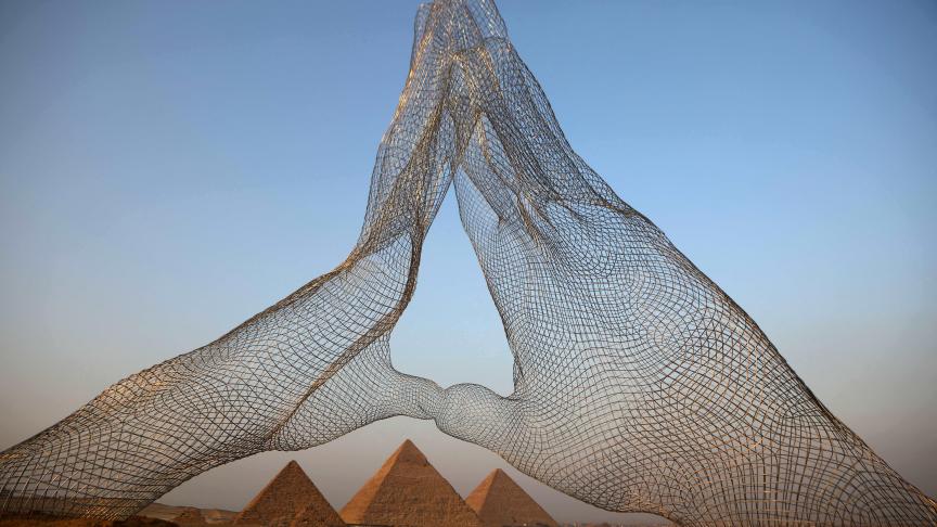 Une installation de l’artiste italien Lorenzo Quinn fait face aux pyramides du plateau de Gizeh.