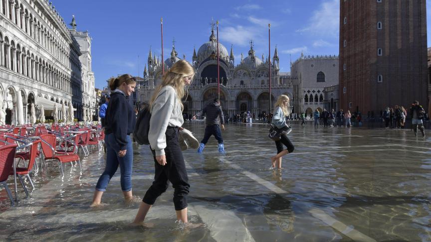 Les gens marchent sur la place Saint-Marc inondée à Venise.