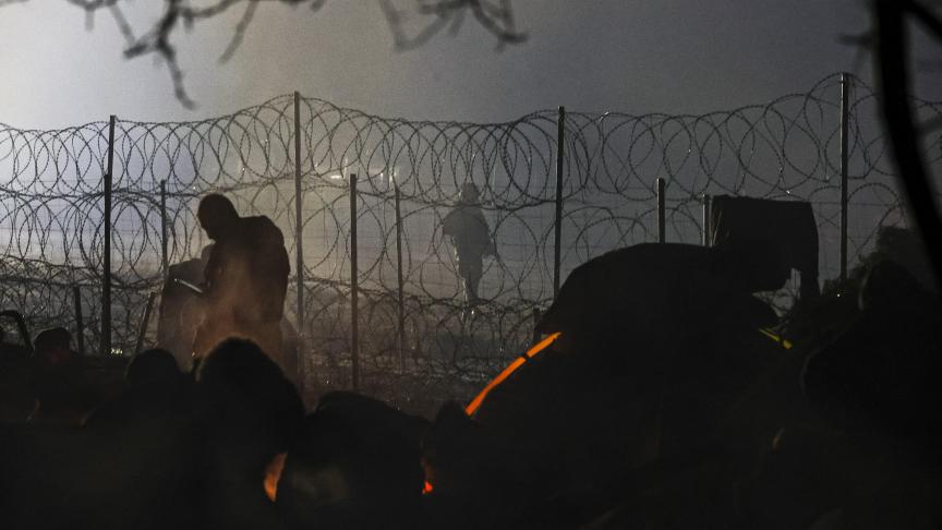 Les gardes frontières polonais surveillent l’arrivée des migrants derrière les barbelés.