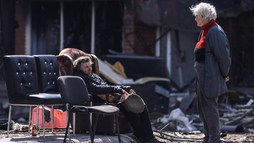 Des femmes discutent devant un bâtiment détruit par les bombardements dans la ville de Marioupol, en Ukraine.