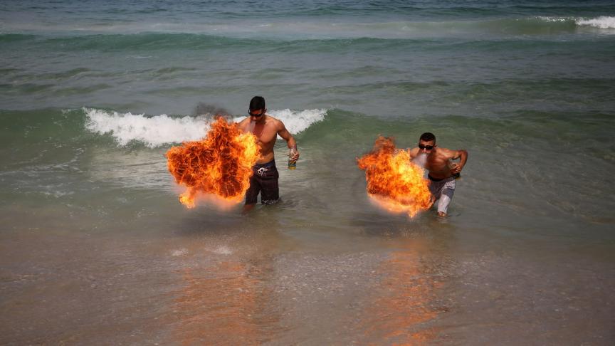 Des Palestiniens soufflent du feu sur la plage de Gaza.