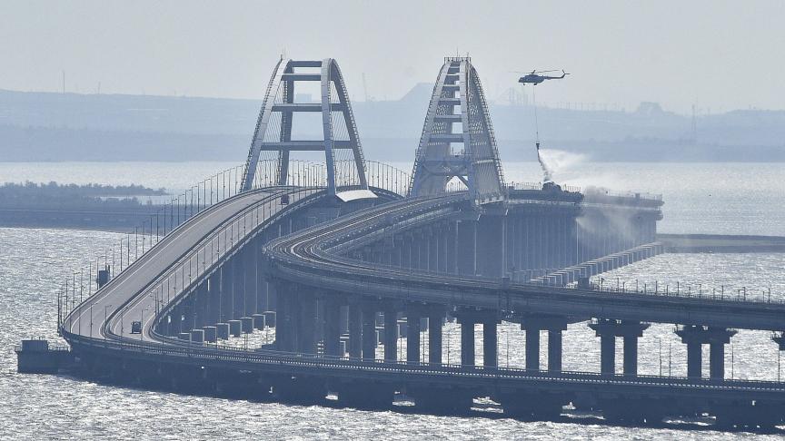 Un hélicoptère largue de l'eau pour arrêter le feu sur le pont de Crimée reliant le continent russe et la péninsule de Crimée.