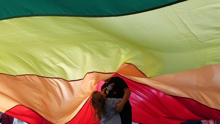 Des enfants jouent sous un grand drapeau lors d'un rassemblement pour la paix et contre la guerre à Rome.