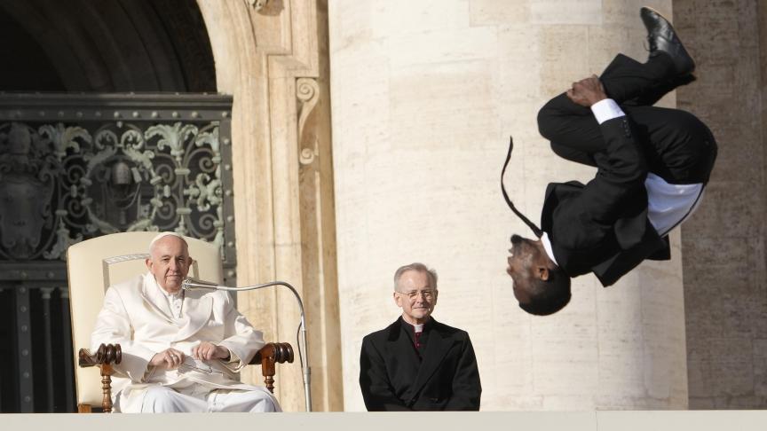 Le pape François regarde un acrobate des «Black Blues Brothers» lors de son audience générale hebdomadaire sur la place Saint-Pierre au Vatican.