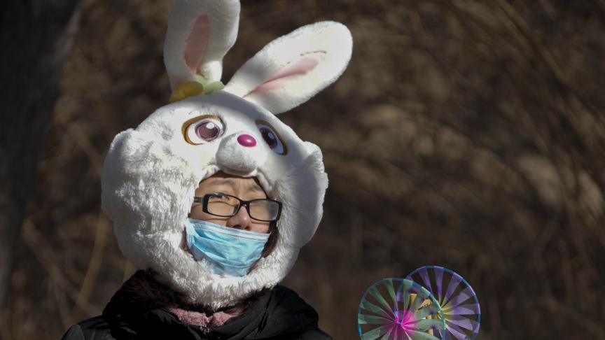 Une femme avec un couvre-chef en forme de lapin au temple du jardin de Yuanmingyuan, au deuxième jour des célébrations du Nouvel An lunaire à Beijing, le lundi 23 janvier 2023.