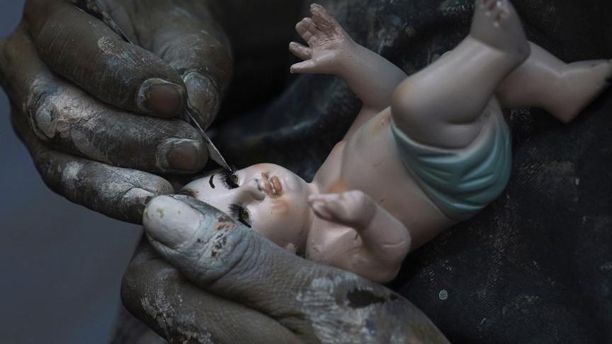 Un homme répare une figurine de l'Enfant Jésus à Mexico City, ce mercredi 25 janvier 2023.